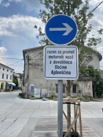 Znak, ki opozarja na enosmerni promet v smeri proti Policiji.