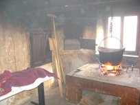 Batičeva hiša s črno kuhinjo in lesenim ognjiščem 